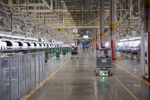 自动化牵引小车穿行在北汽株洲基地二工厂的总装车间里。