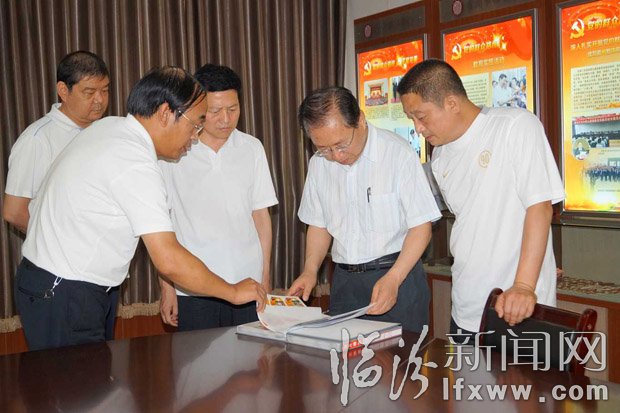 梁组长一行在查阅照片档案。