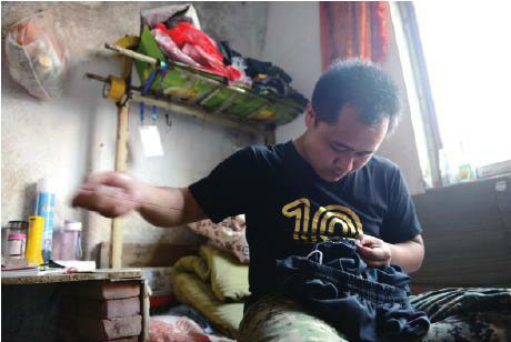 孙涛在为自己缝补衣服