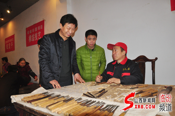 03、临汾市非物质文化遗产主任任江波（左一）在向制作师傅了解晋作家具制作雕刻技艺