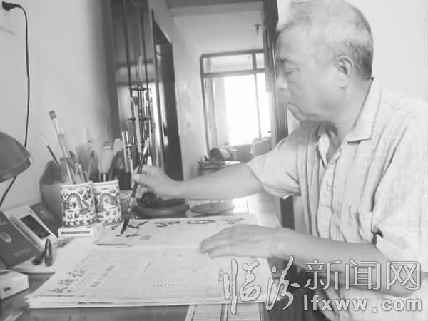 李枫正在报纸上练习写毛笔字。