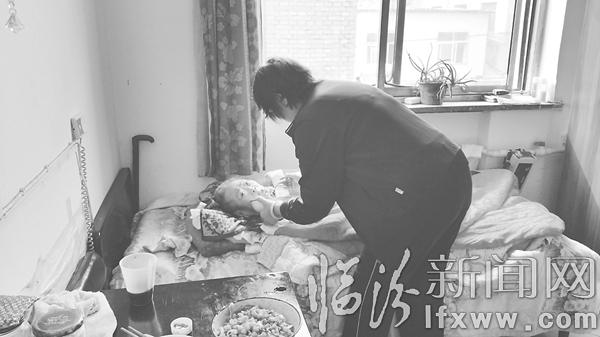 一位护工正在给老人喂饭。