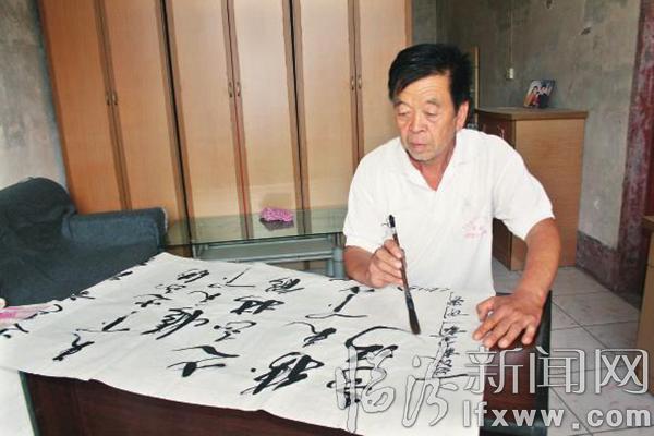 闫小林正在挥毫泼墨。