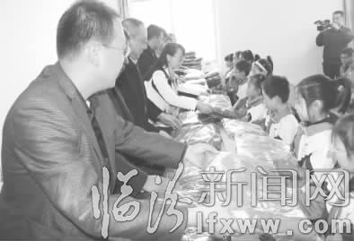 成员们为学生们赠送冬装校服。