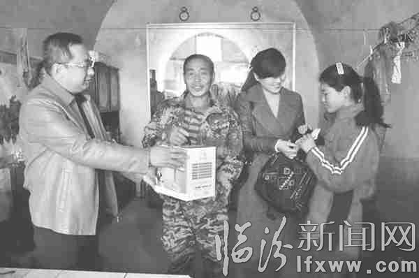 图为工作人员为帮扶对象送去慰问金和学习用品