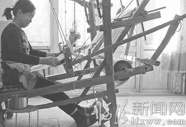 张月玲正在操作手工织布机