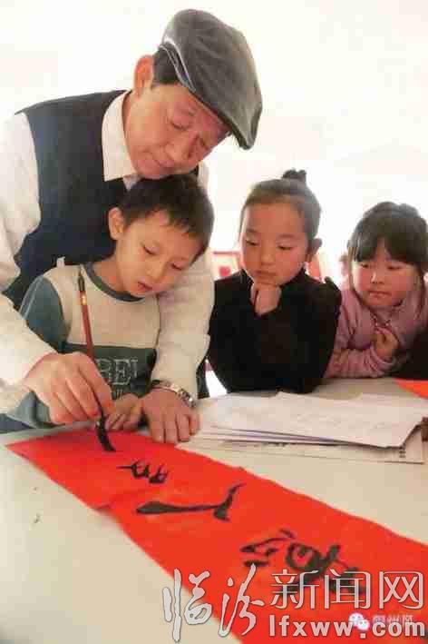 小朋友向解绍亮学写春联,继承优秀传统文化。 通讯员微微摄