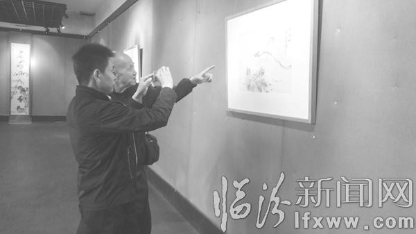 图为书画爱好者正在观看画展