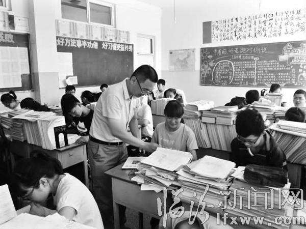 谭志俊给学生辅导作业。