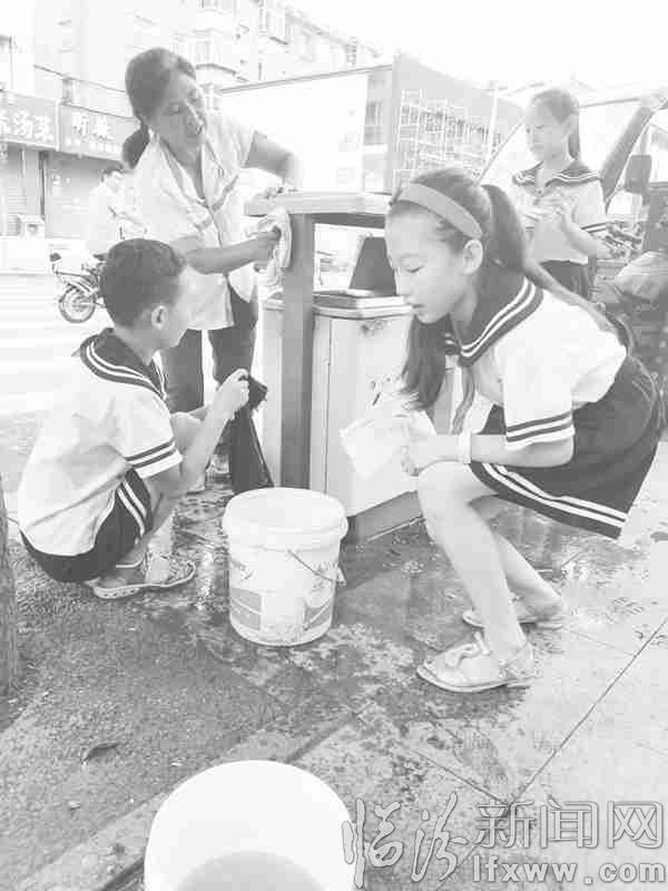 学生们正在清洗垃圾箱