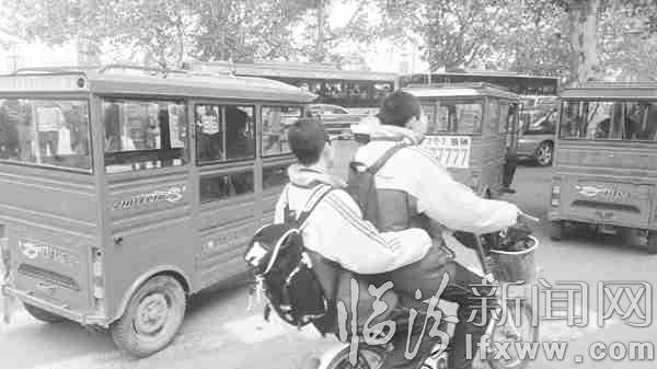 正在招揽生意的“野三轮”停泊在非机动车道上,严重影响行人通过