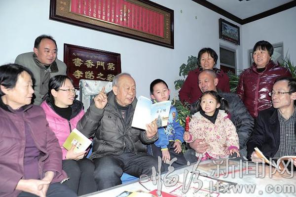 刘春澍老人(中)给家人讲起了传统文化经典《弟子规》。