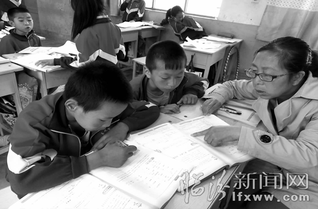 赵烨在辅导学生写作业。