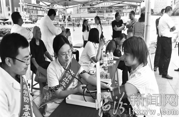 工作人员为市民测量血压。