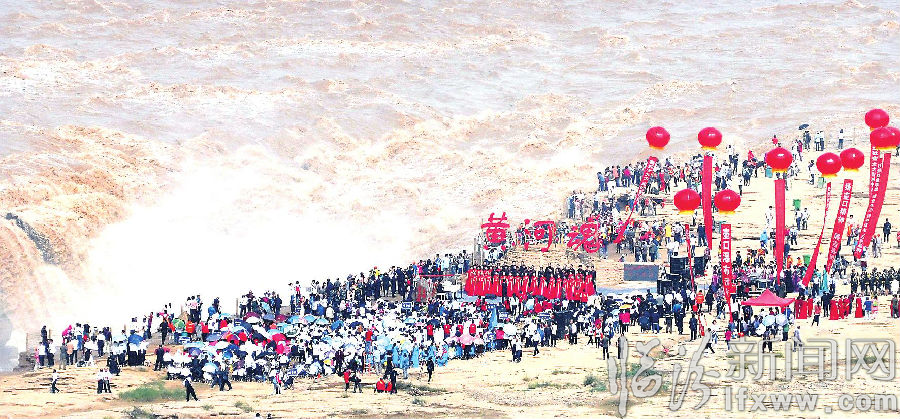 9月18日,众多游客在吉县黄河壶口瀑布景区欣赏“歌唱黄河”合唱展演。 当日,2017山西(吉县)黄河壶口文化旅游招商系列活动暨“歌唱黄河”合唱艺术周开幕,北京军旅之声艺术团等8支合唱团进行了合唱展演。 吕桂明 摄影报道