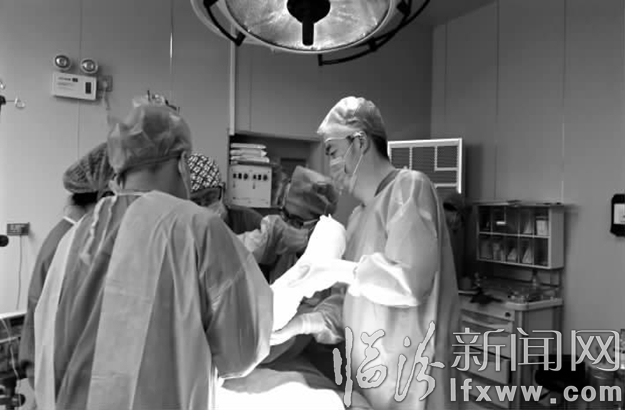 晋强(右一)带领烧伤团队为患儿做植皮手术。