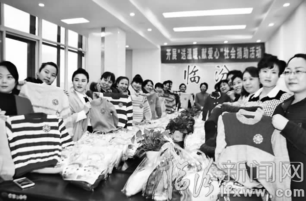 尧都区妇联组织平阳之花艺术团为贫困山区孩子编织毛衣。